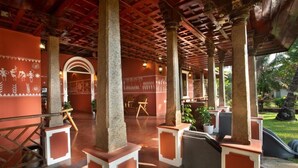 An indoor area with a wooden ceiling, columns, and a view of the outdoors. - Ananda Cherai (Kochi)