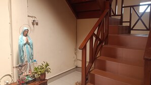 A statue of the Virgin Mary in a blue robe, a wooden bench, and a staircase with wooden railings. - Hotel O Lourdes Blessing Hill (Manado)