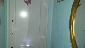 A white door with a small window and a pink butterfly decoration. There is a framed picture on the wall and a gold-framed mirror to the right. - Room-2 Floors 3 Bedrooms Near Central St (Antwerp)