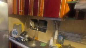 A kitchen with wooden cabinets, a stainless steel sink, and a microwave. - Room-2 Floors 3 Bedrooms Near Central St (Antwerp)