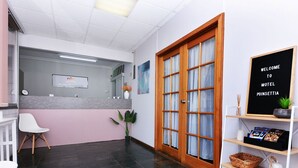 A reception area with a reception desk, a clock, a plant, and a welcome sign. - Motel Poinsettia (Port Augusta West)