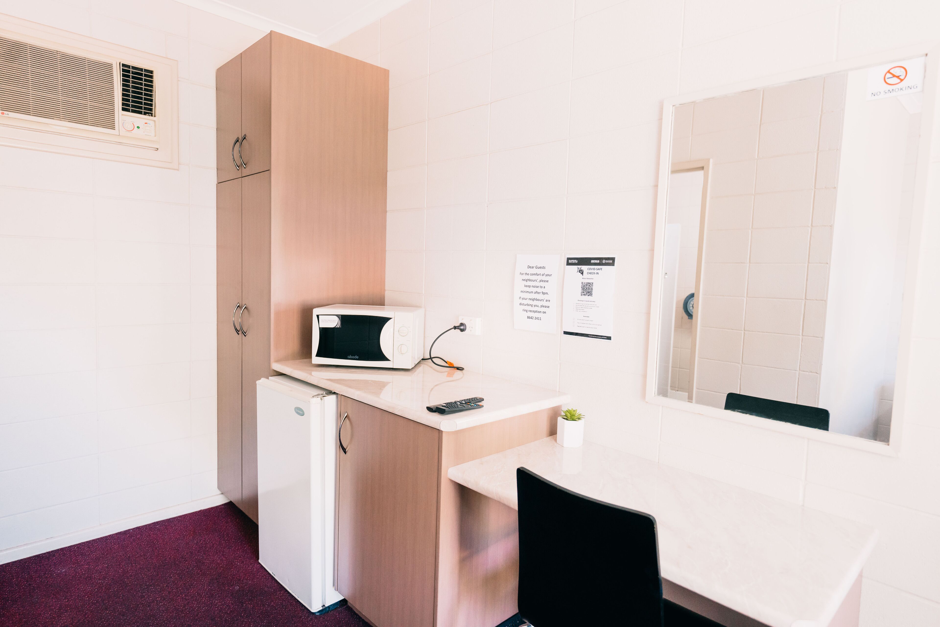A compact kitchenette with a microwave, a small refrigerator, and a sink.