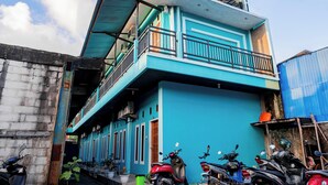 A two-story building with a balcony on the upper floor. - Hotel O Rinjani Guest House (Balikpapan)