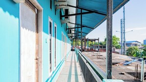 A blue building with a covered walkway and a view of the surrounding area. - Hotel O Rinjani Guest House (Balikpapan)