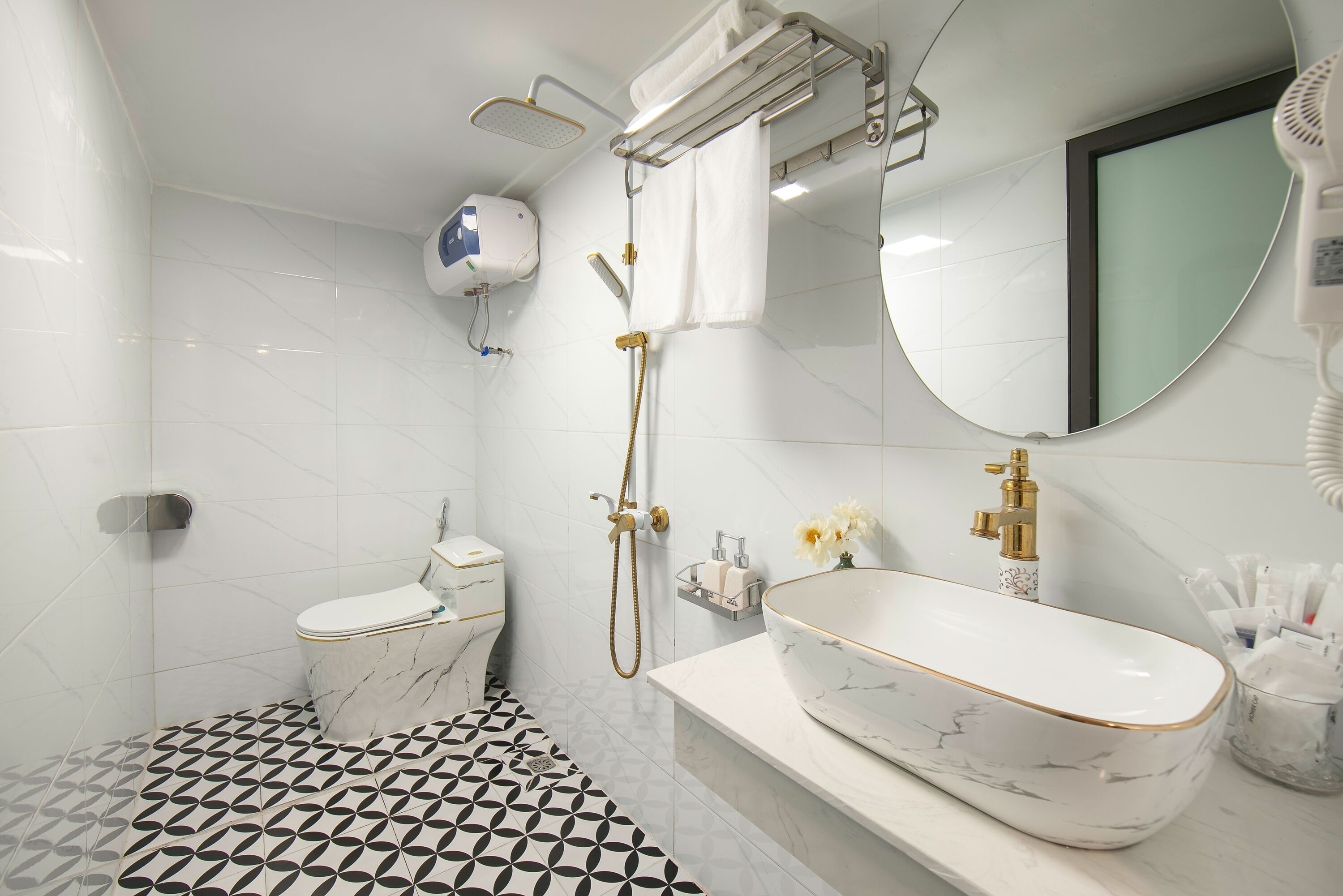 A bathroom with a toilet, bidet, and a large marble sink with a mirror above it.
