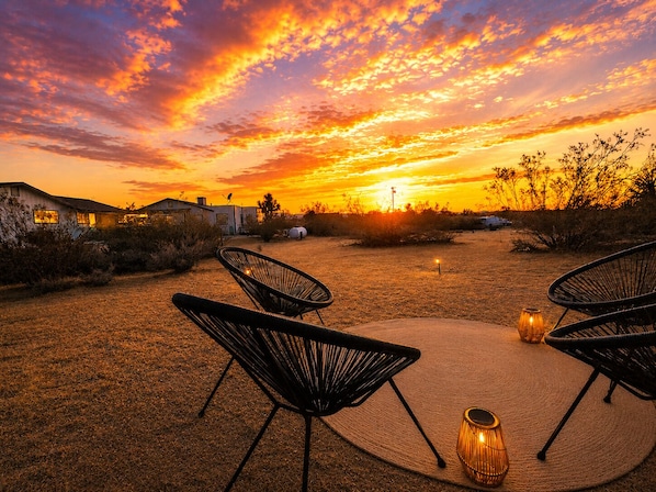 A sunset view with outdoor seating and a building in the background.