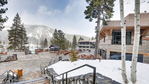 A snow-covered outdoor area with stone steps, wooden benches, and a building with large windows. - Breathtaking Olympic Valley Gem: Walk to Chairlift (Olympic Valley)