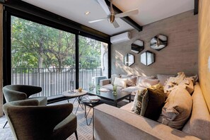 A modern living room with a sofa, armchairs, a coffee table, and a view through large windows. - Artful Living in Polanco | 3BR w/ Fast Wifi (Ciudad de México)