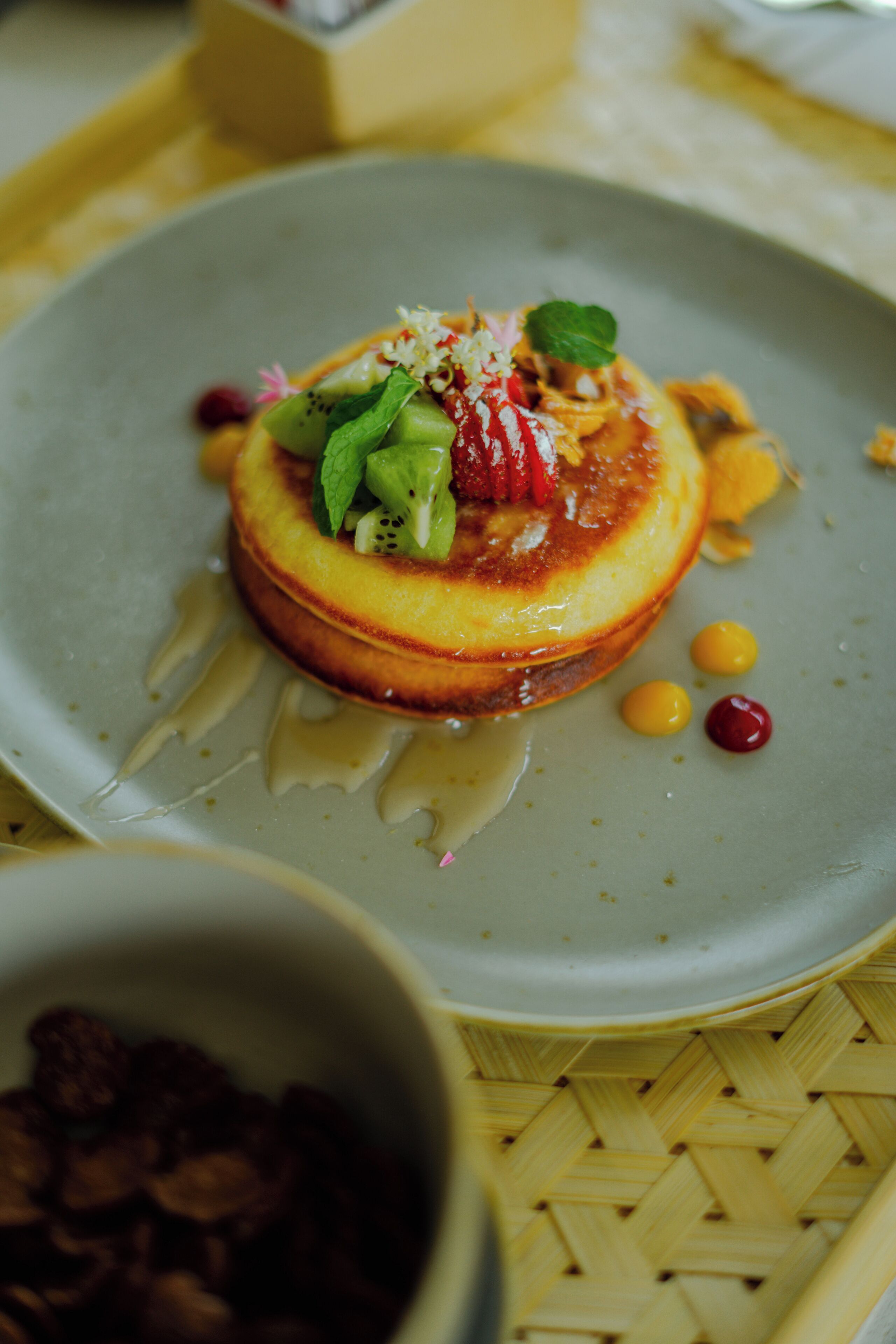 A dessert on a plate with a drizzle of sauce and garnishes.