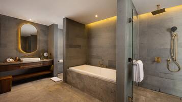 A modern bathroom with a large bathtub, a glass-enclosed shower, and a vanity with a mirror.