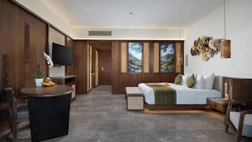Una habitación de hotel moderna con una cama, un escritorio, un televisor y un ventanal con vistas a la montaña.