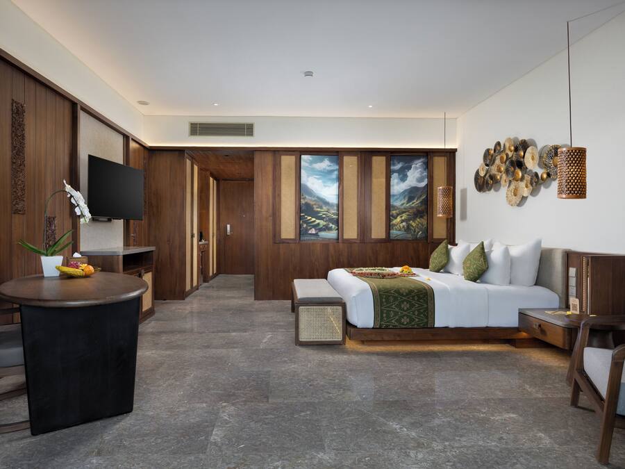 Una habitación de hotel moderna con una cama, un escritorio, un televisor y un ventanal con vistas a la montaña.
