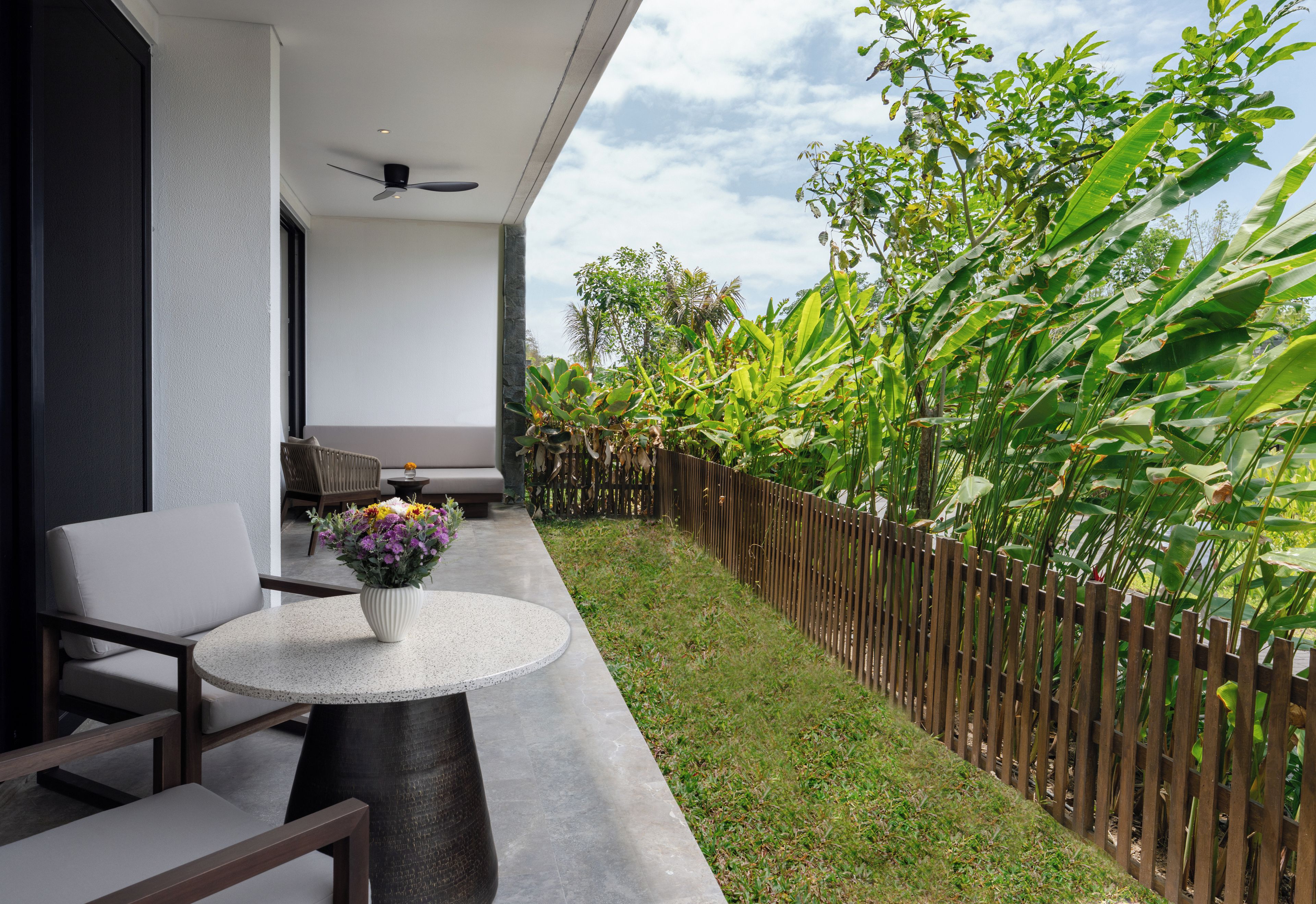 A balcony with a round table, a chair, and a potted plant.