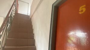 Een trap die leidt naar een deur met het nummer 5.
