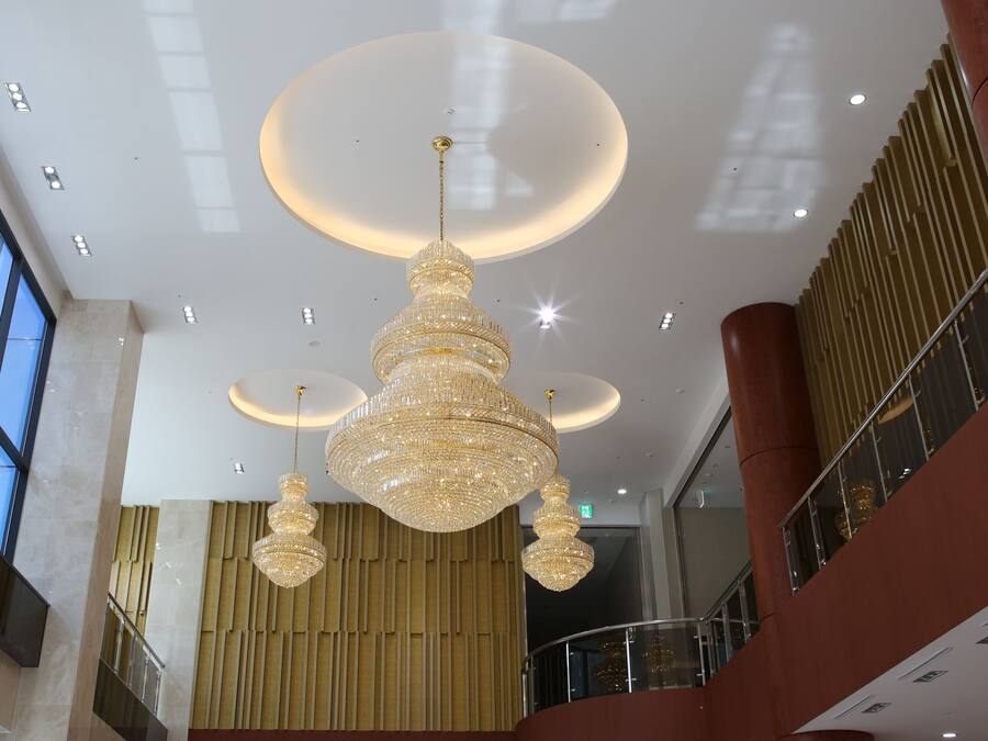 A spacious interior with a large chandelier, high ceilings, and a modern design.