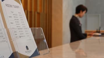 A hotel room tariff board with room types and rates.
