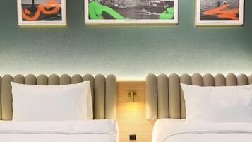 Una habitación de hotel con dos camas, un cabecero de madera y tres cuadros en la pared.