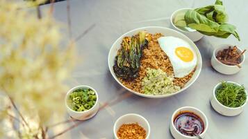Eine Mahlzeit mit Reis, Ei und Gemüse auf einem Tisch, ergänzt durch kleine Schalen mit Beilagen und Salat.