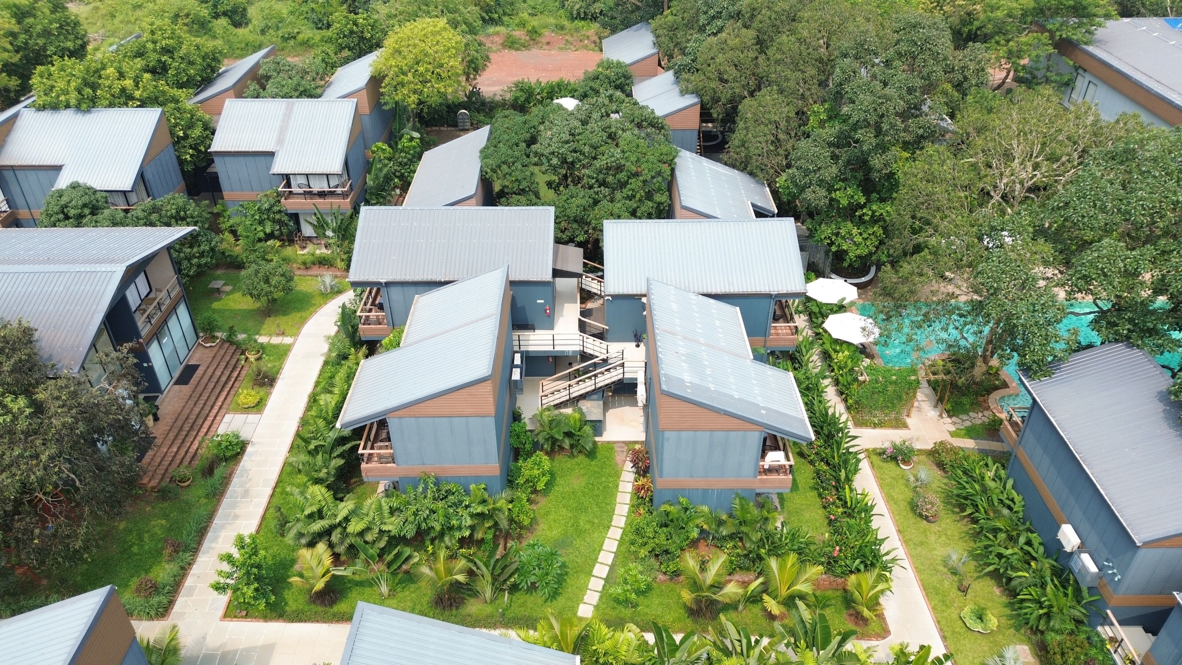 A residential complex with multiple two-story houses, a central staircase, and a swimming pool.