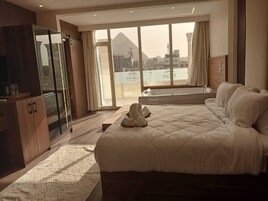 Un dormitorio con una cama grande, un armario de madera y vistas a la montaña a través de amplios ventanales.