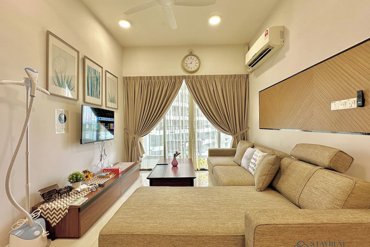 A modern living room with a sofa, a coffee table, a TV, and a ceiling fan.