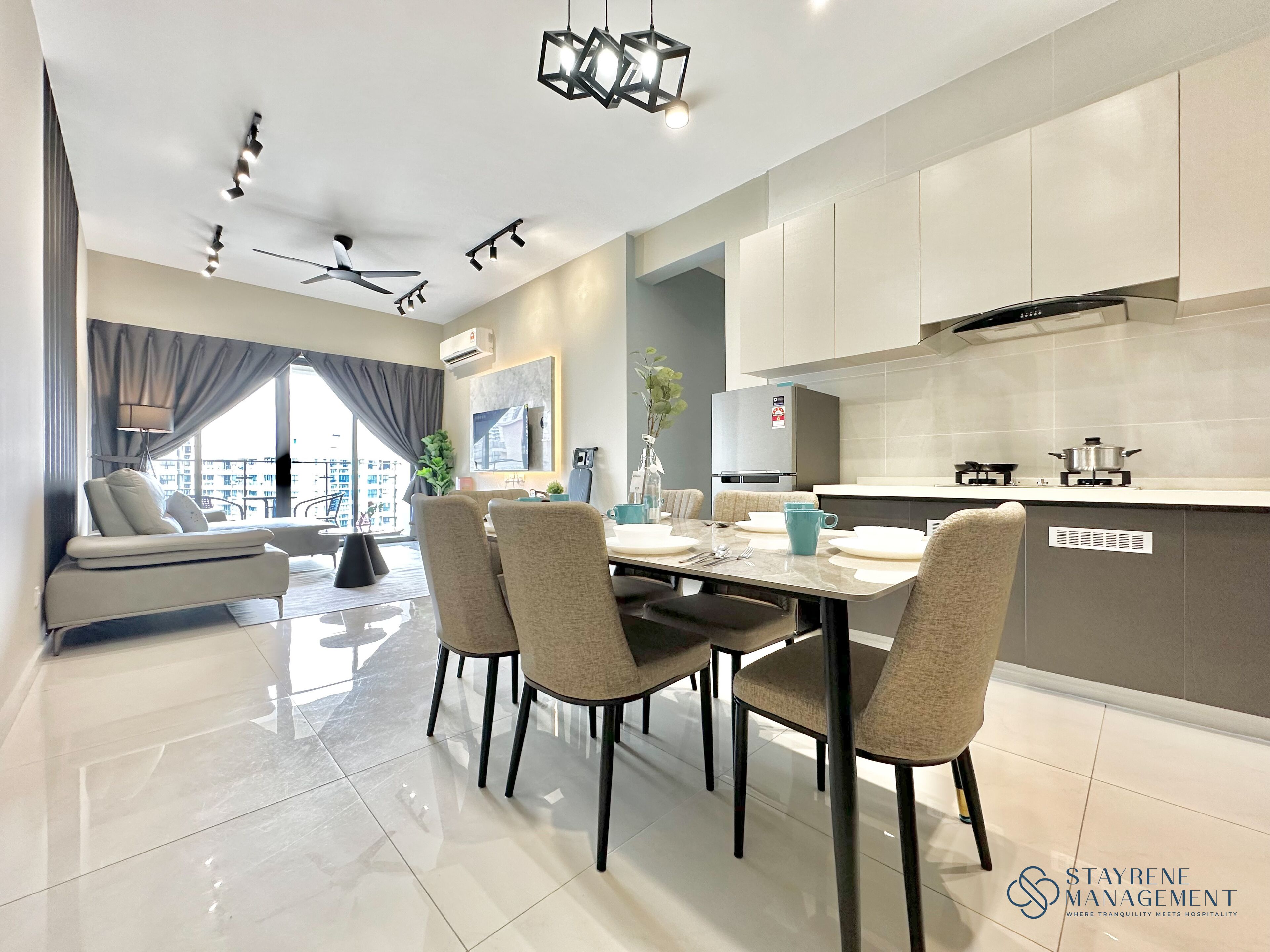 A modern kitchen with a dining area, featuring a large window, a ceiling fan, and a built-in stove.