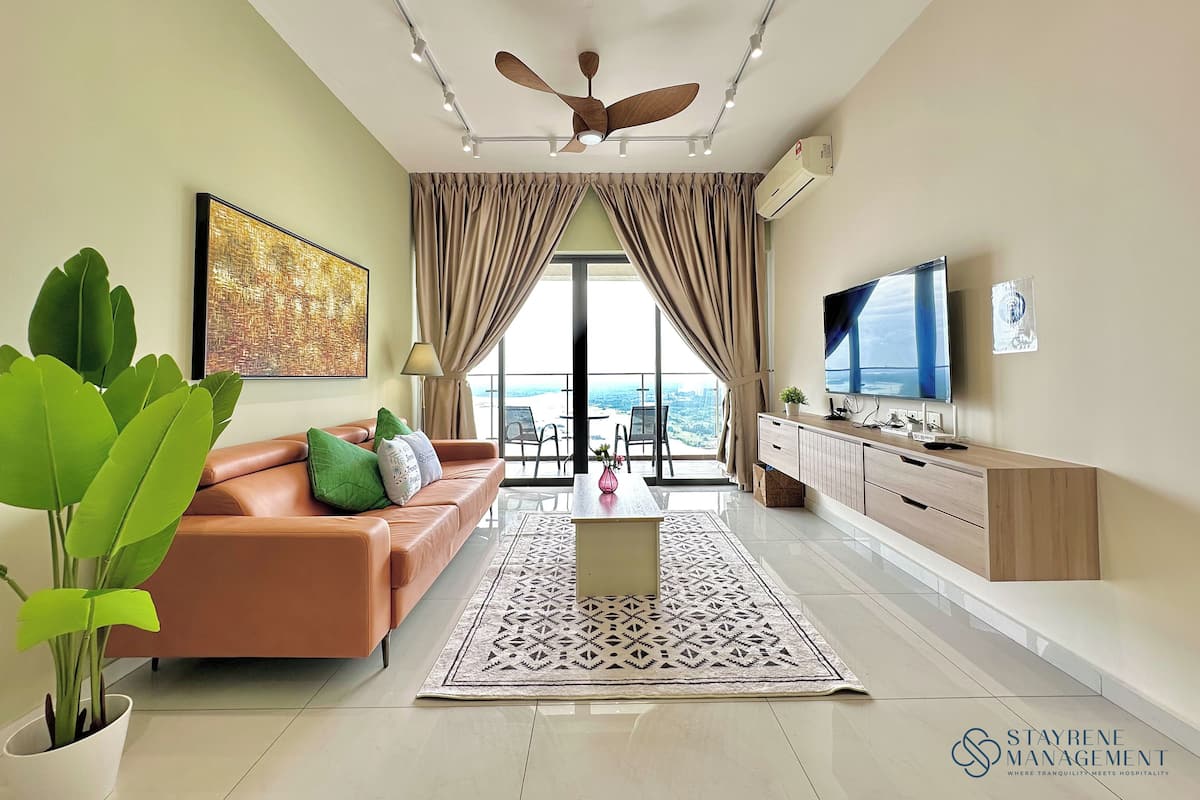A modern living room with a sofa, a coffee table, a TV, and a ceiling fan.