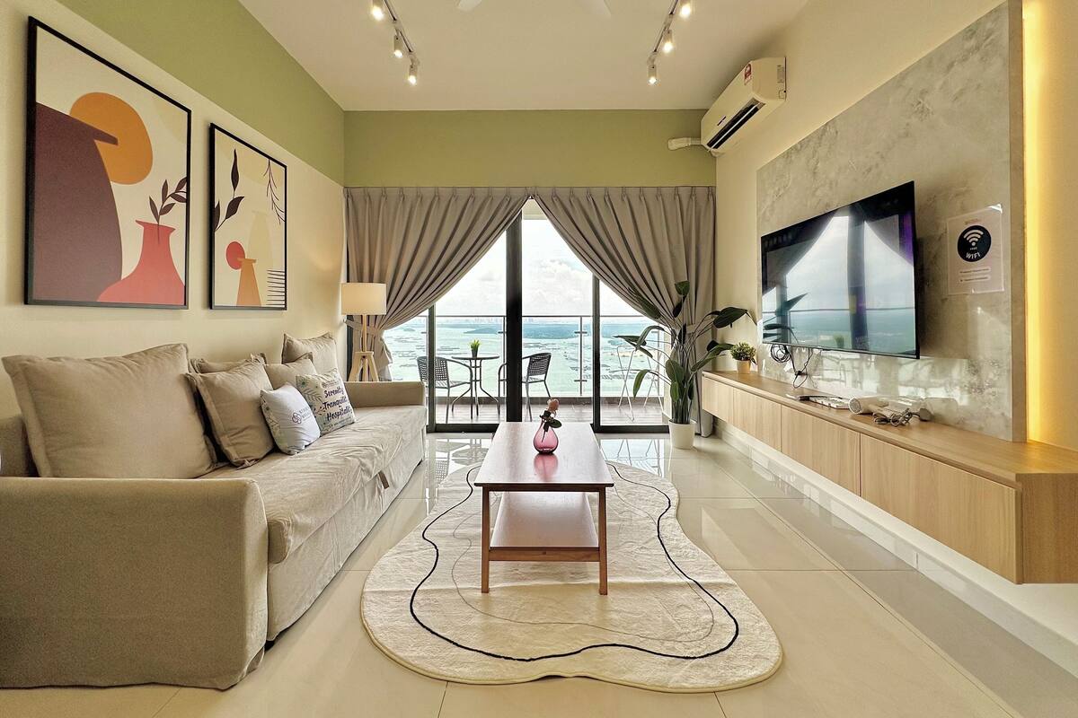 A modern living room with a sofa, coffee table, and artwork on the walls.