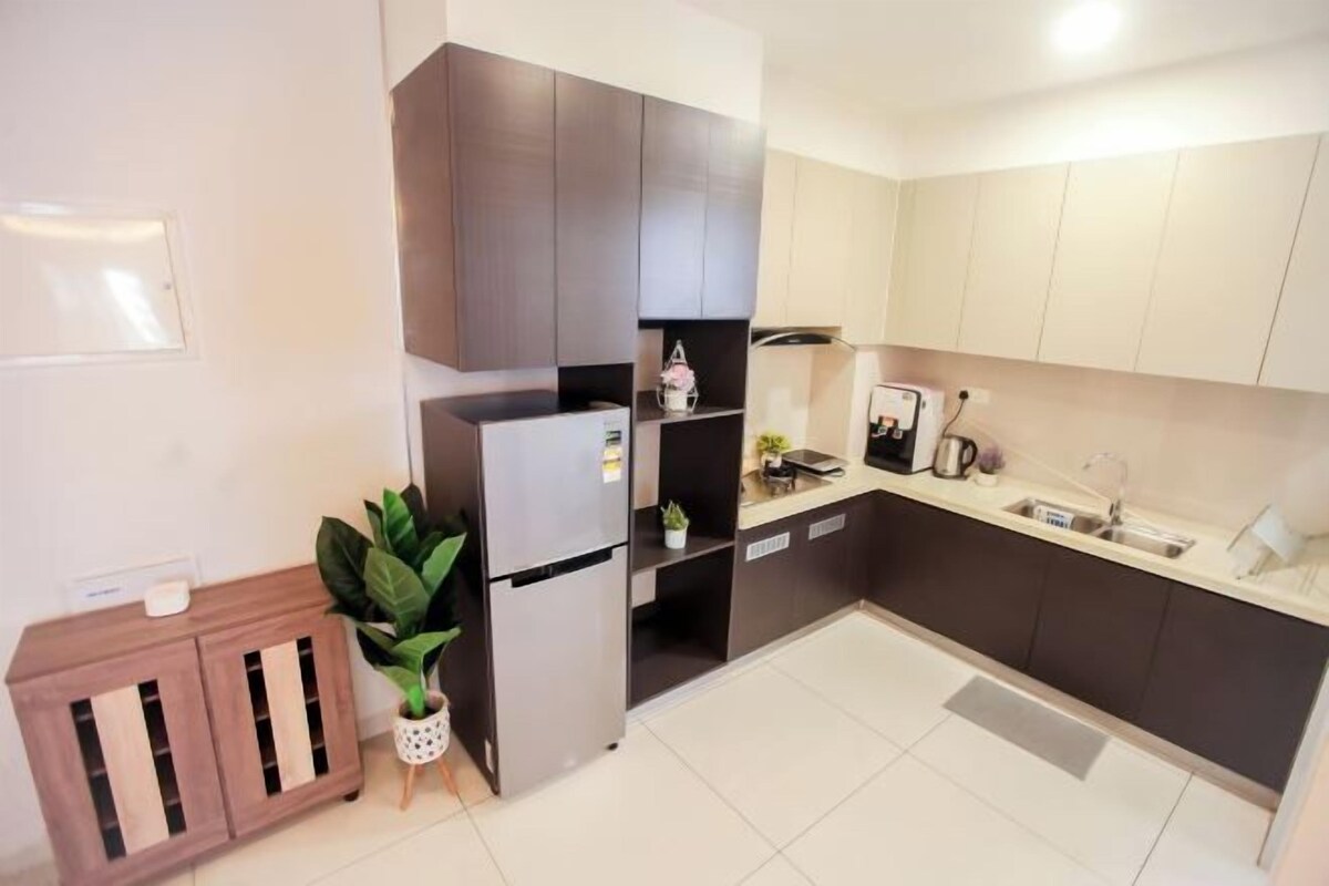 A modern kitchen with a refrigerator, cabinets, and a sink.