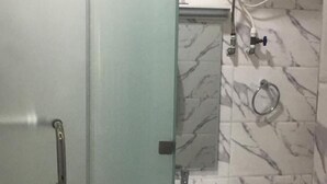 A bathroom with a glass shower door, a white sink, and a toilet. - Stunning 2-bed Apartment in Lagos (Lagos)
