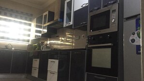 A kitchen with black and silver appliances, including a microwave, oven, and coffee maker. - Stunning 2-bed Apartment in Lagos (Lagos)