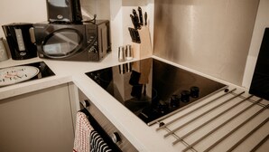 Uma cozinha compacta com micro-ondas, torradeira e fogão.