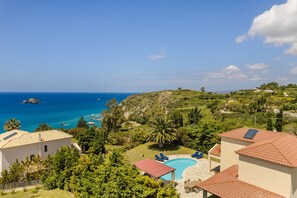 A residential area with a swimming pool, houses with red-tiled roofs, and a view of the sea. - Private Villa Helios, in Cape Liakas, Spartia, Kefalonia (Spartià)