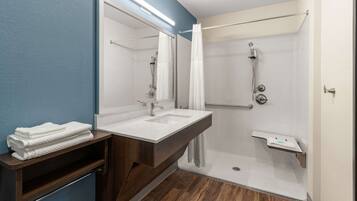 Une salle de bain moderne avec un grand miroir, deux vasques, une douche et un meuble-lavabo en bois.