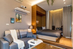 Une chambre d’hôtel moderne équipée d’un canapé, d’un lit, d’une petite table et d’un bureau.