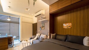 A modern hotel room with a large bed, a seating area with a small table, and a desk with a chair. - 1B1b Cinema, Kitchen, Bathtub, Desk, 1.5min to MRT (Taipei City)