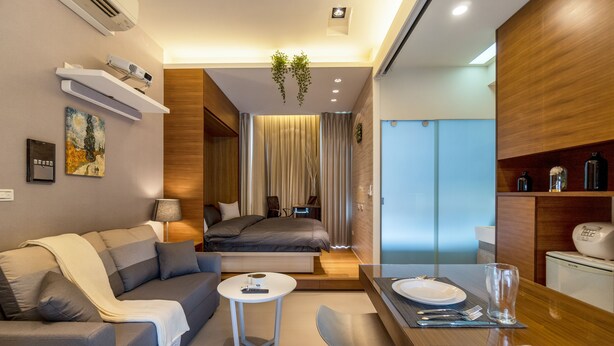 A modern hotel room with a sofa, a small round table, a bed with curtains, a dining area with a table set for two, and a built-in shelf with bottles. - 1B1b Cinema, Kitchen, Bathtub, Desk, 1.5min to MRT (Taipei City)