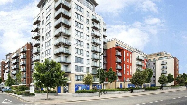 A multi-story residential building with balconies, a pedestrian pathway, and a clear sky. - London - Apartment - Sleeps 2 - Garden - Pool (London)