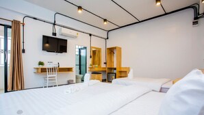 A modern hotel room with a large bed, a desk with a chair, a TV, and a wardrobe. - Thaphon Residence (Phetchabun)