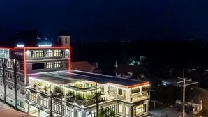 A multi-story hotel with a rooftop terrace and illuminated balconies. - Thaphon Residence (Phetchabun)