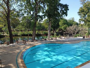 A swimming pool with lounge chairs and a surrounding garden. - Siam Villa Suvarnabhumi (Bangkok)