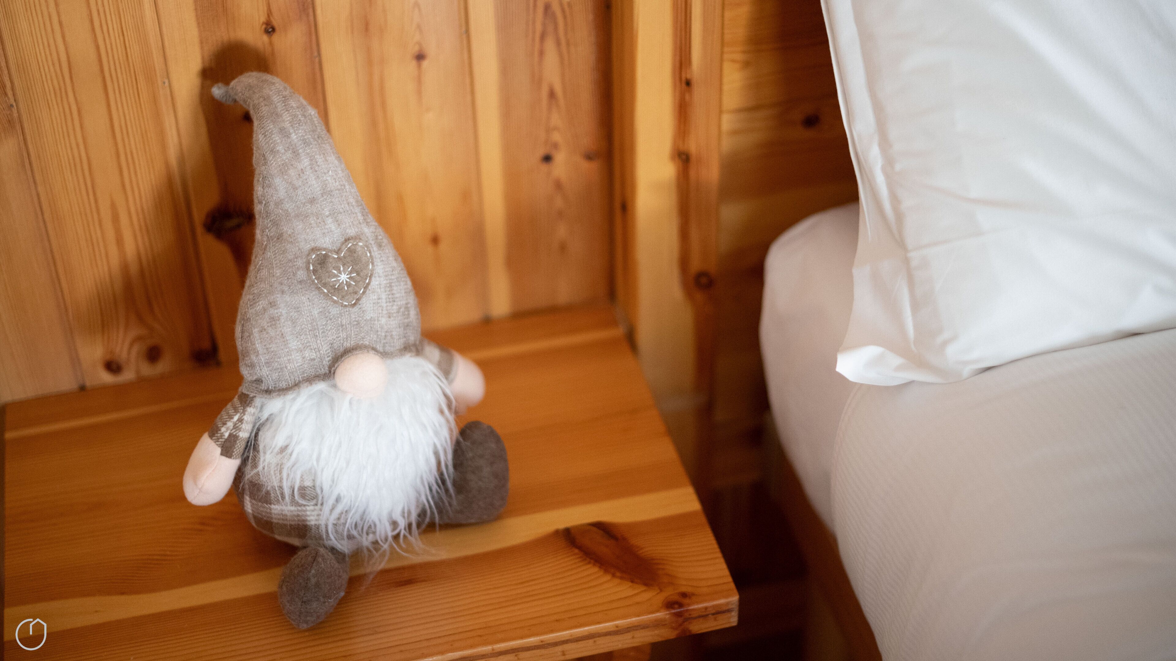 Uma mesa de cabeceira de madeira com uma estatueta decorativa de gnomo.