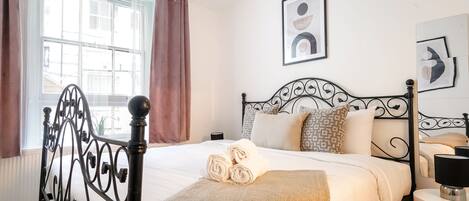 2 habitaciones, escritorio y tabla de planchar con plancha