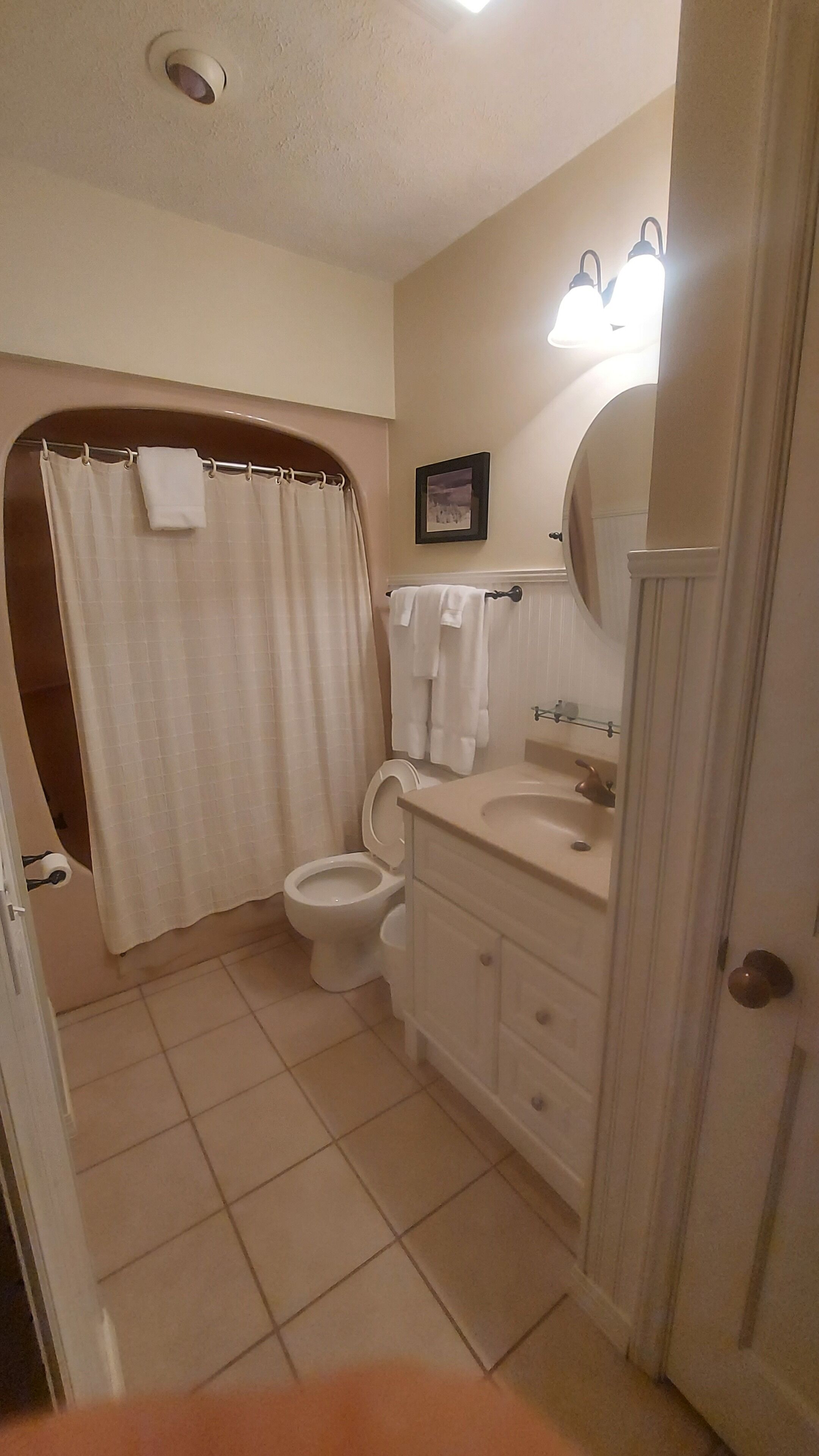 Une salle de bain comprenant des toilettes, un lavabo et un espace douche.