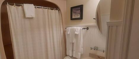 Une salle de bain comprenant des toilettes, un lavabo et un espace douche.