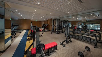 Una palestra con tapis roulant, macchinari per pesi e pesi liberi.