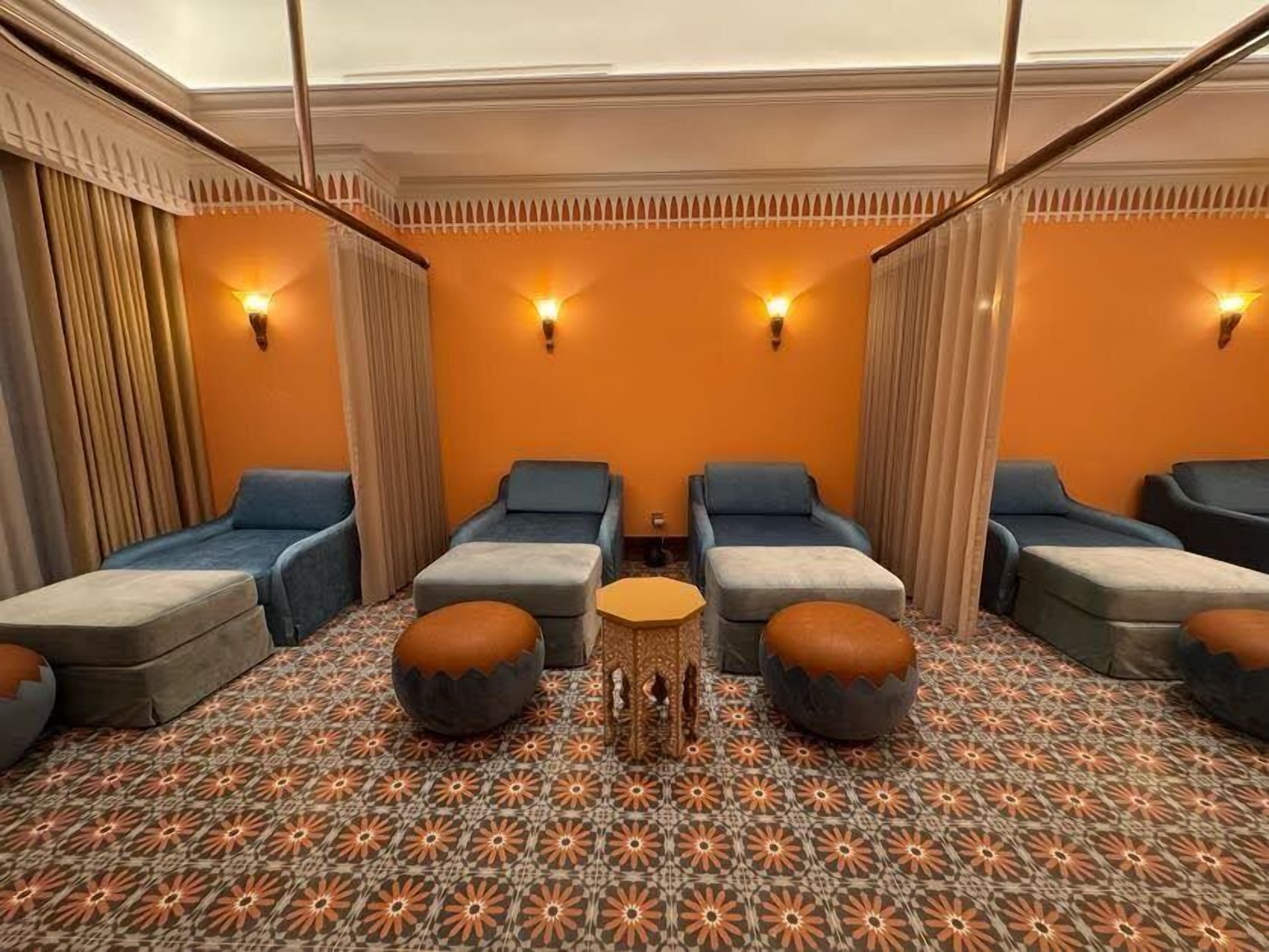 A room with four massage chairs, a small round table, and patterned carpet.