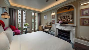 Un dormitorio amplio con una cama grande, una chimenea y vistas a la ciudad a través de amplios ventanales.