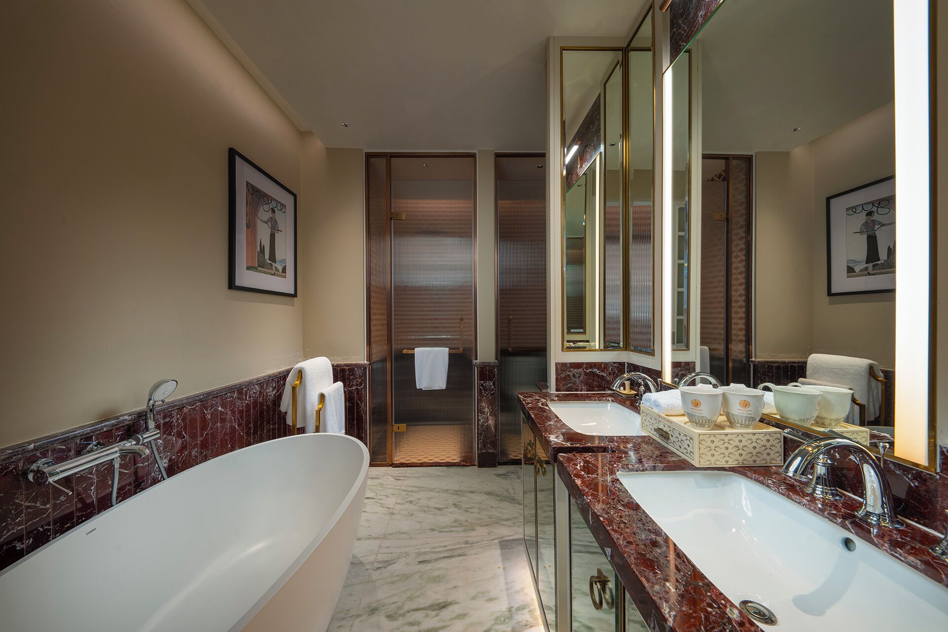A modern bathroom with a large bathtub, two sinks, and a walk-in shower.