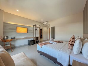 A modern hotel room with a bed, a desk, a television, and a mirror. - Front One Hotel Gombong (Gombong)